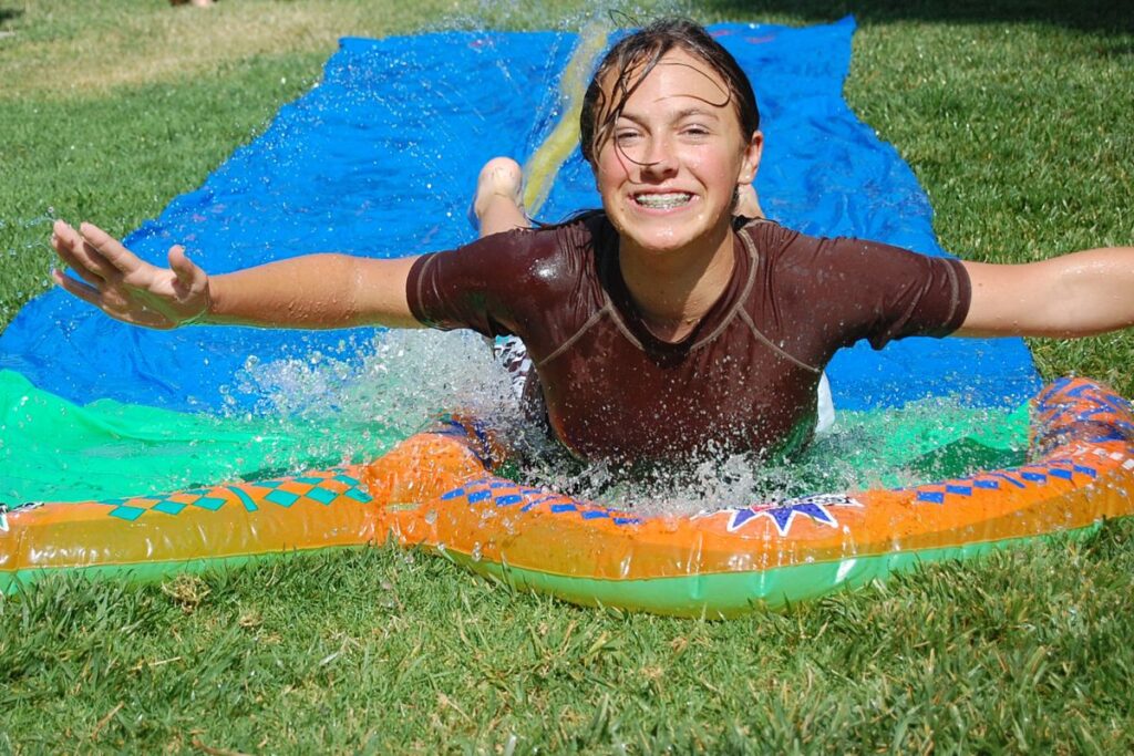 a teen girl going down a slip n slide